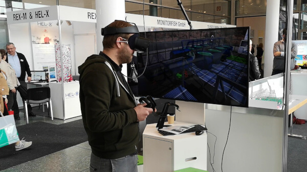 Messebesucher mit einer Virtual Reality Brille und Controllern. für die Interaktion mit einer Aquaponik Anlage